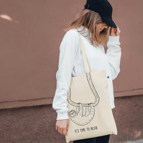 Frau trägt Jutebeutel mit Faultier-Aufdruck über der Schulter